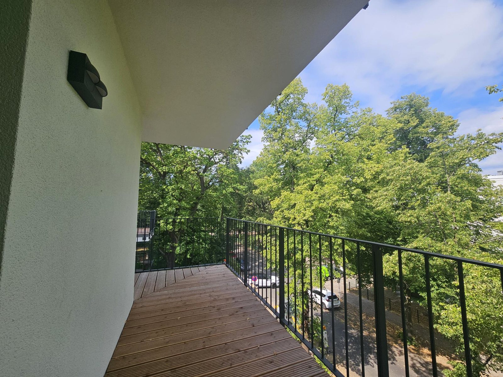 Über Eck laufende Panorama-Terrasse mit Holzboden und Blick ins Grüne